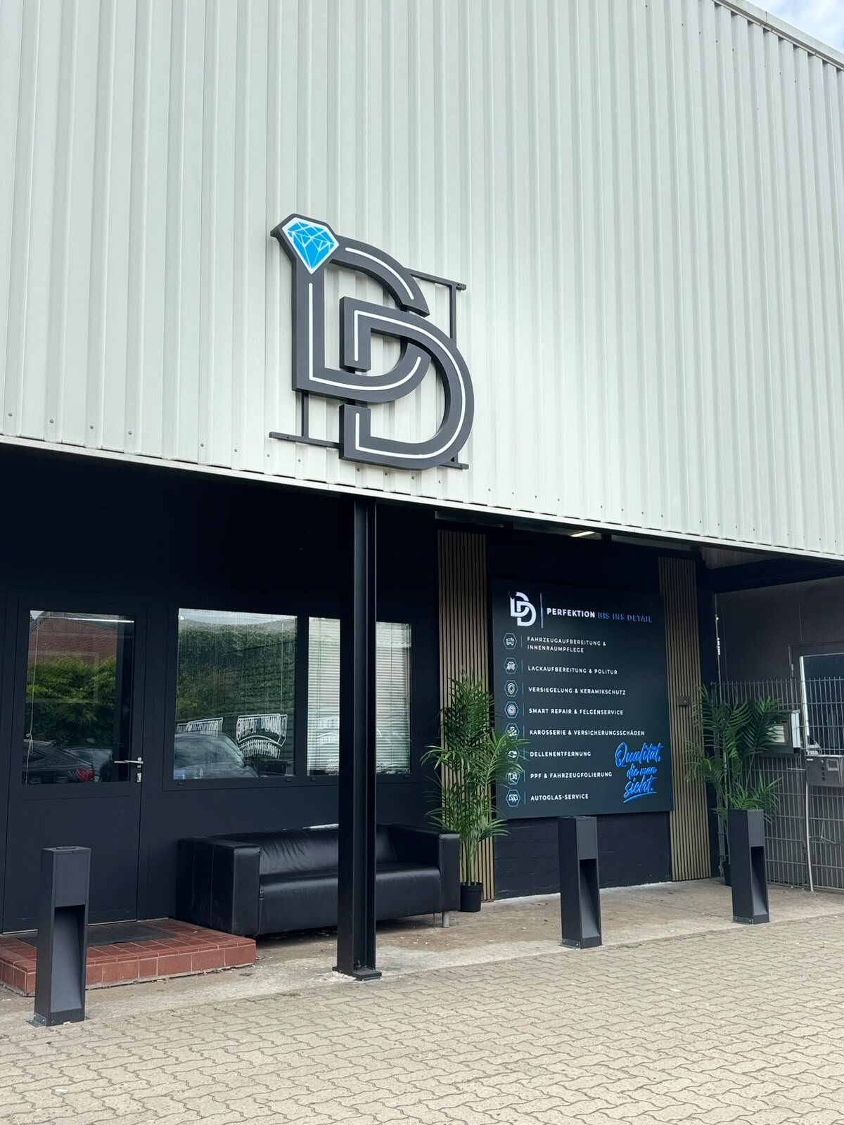 Eingang von Diamond Detailing in Neu Wulmstorf mit Logo und Leistungstafel